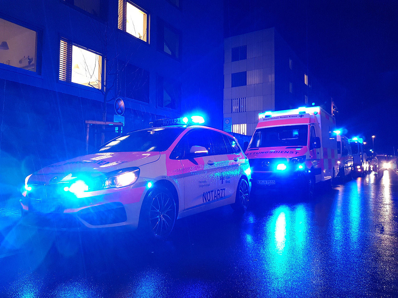 Mehrere Einsatzfahrzeuge verschiedener Hilfsorganisationen stehen mit Blaulicht vor dem Klinikum.