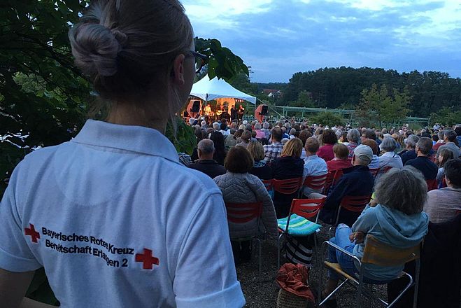 Eine Sanitäterin beobachtet die Zuschauer eines Konzertes