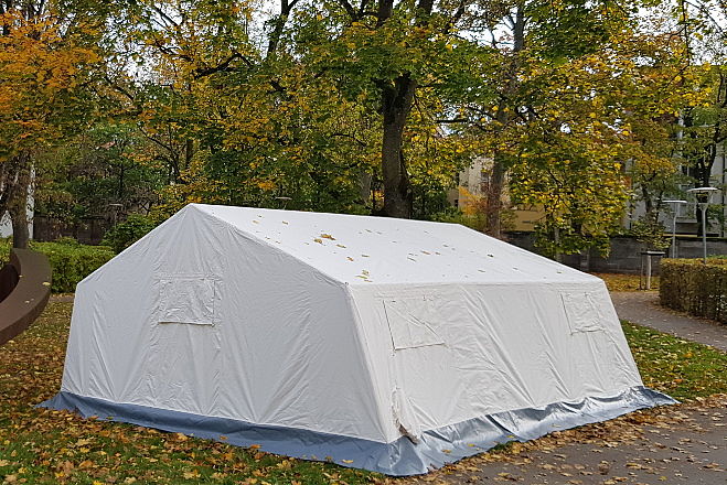 Zelt des Typs SG 30 aufgebaut unter Bäumen.